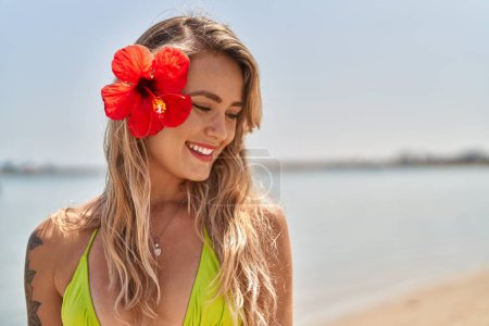 Téléchargez les photos : Jeune femme touriste portant bikini souriant confiant au bord de la mer - en image libre de droit