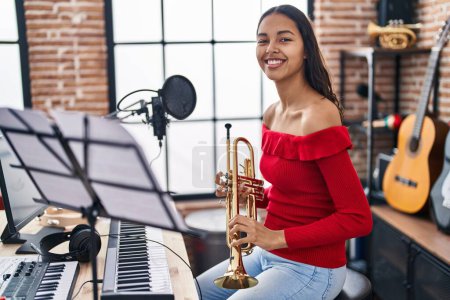 Foto de Joven afroamericana músico tocando trompeta en estudio de música - Imagen libre de derechos
