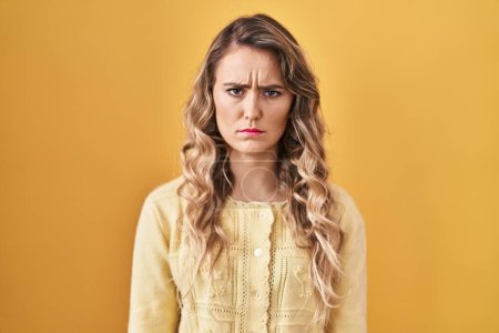 Photo for Young caucasian woman standing over yellow background skeptic and nervous, frowning upset because of problem. negative person. - Royalty Free Image