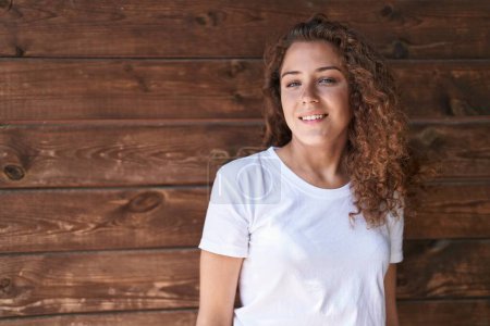 Téléchargez les photos : Young beautiful hispanic woman smiling confident standing over isolated wooden background - en image libre de droit