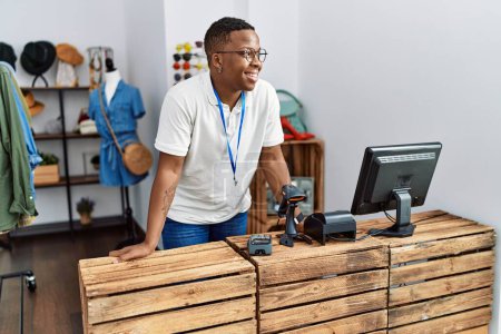 Téléchargez les photos : Young african man working as shop assistance at retail shop - en image libre de droit