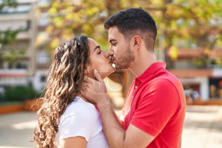 Téléchargez les photos : Jeune couple hispanique souriant confiant s'embrassant et s'embrassant au parc - en image libre de droit