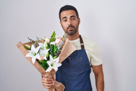 Photo for Hispanic man with beard working as florist looking sleepy and tired, exhausted for fatigue and hangover, lazy eyes in the morning. - Royalty Free Image