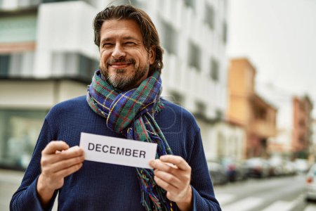Foto de Hombre guapo de mediana edad sosteniendo la pancarta de diciembre en la ciudad - Imagen libre de derechos
