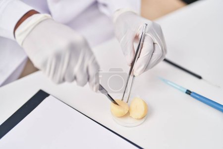 Photo for African american woman wearing scientist uniform analysing sample at laboratory - Royalty Free Image