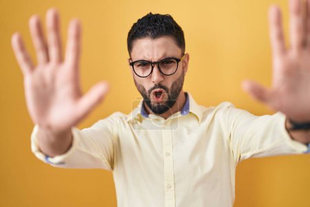 Photo for Hispanic young man wearing business clothes and glasses doing stop gesture with hands palms, angry and frustration expression - Royalty Free Image