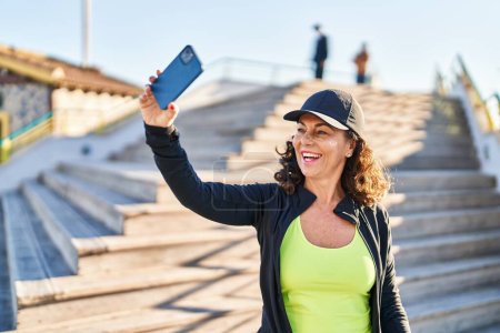 Photo for Middle age hispanic woman working out taking selfie picture outdoors - Royalty Free Image