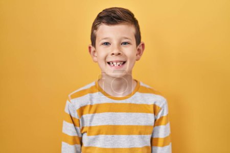 Foto de Young caucasian kid standing over yellow background with a happy and cool smile on face. lucky person. - Imagen libre de derechos