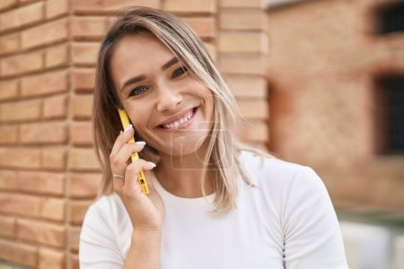 Photo for Young caucasian woman smiling confident talking on the smartphone at street - Royalty Free Image