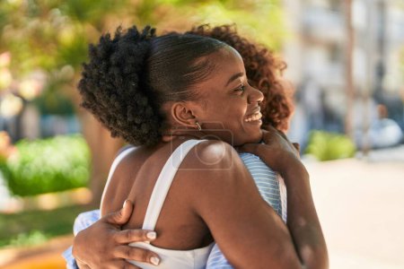 Téléchargez les photos : Les femmes afro-américaines mère et fille se câlinent au parc - en image libre de droit