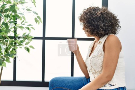 Photo for Young middle east woman smiling confident drinking coffee at home - Royalty Free Image
