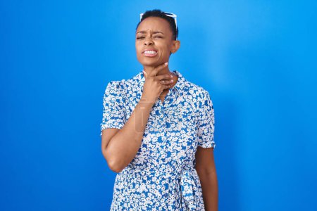 Photo for African american woman standing over blue background touching painful neck, sore throat for flu, clod and infection - Royalty Free Image