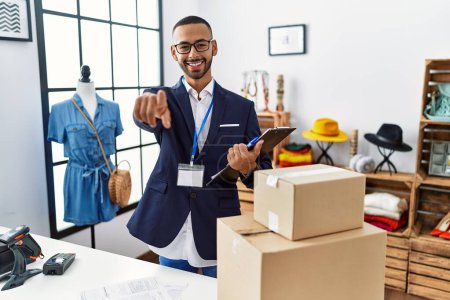 Foto de African american man working as manager at retail boutique pointing to you and the camera with fingers, smiling positive and cheerful - Imagen libre de derechos
