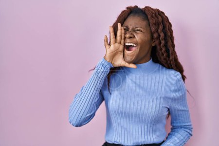 Photo for African woman standing over pink background shouting and screaming loud to side with hand on mouth. communication concept. - Royalty Free Image