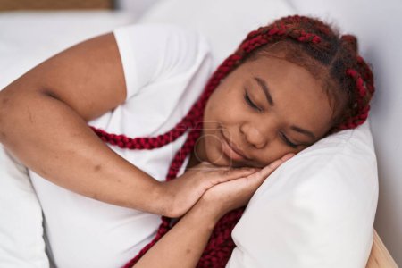 Téléchargez les photos : Femme afro-américaine couchée sur le lit dormant dans la chambre - en image libre de droit