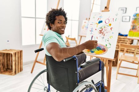 Foto de Joven afroamericano discapacitado artista hombre sentado en silla de ruedas dibujo en el estudio de arte. - Imagen libre de derechos
