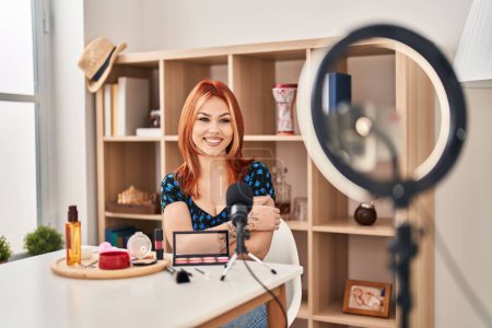 Téléchargez les photos : Young caucasian woman applying make up doing tutorial happy face smiling with crossed arms looking at the camera. positive person. - en image libre de droit