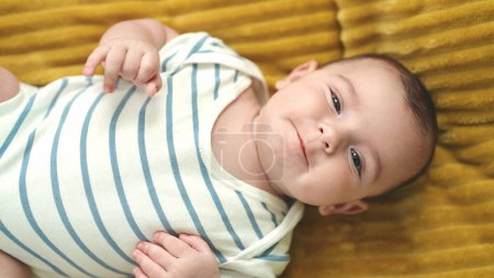 Foto de Adorable bebé caucásico sonriendo confiado acostado en la manta en casa - Imagen libre de derechos