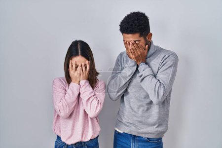 Photo for Young hispanic couple standing together with sad expression covering face with hands while crying. depression concept. - Royalty Free Image