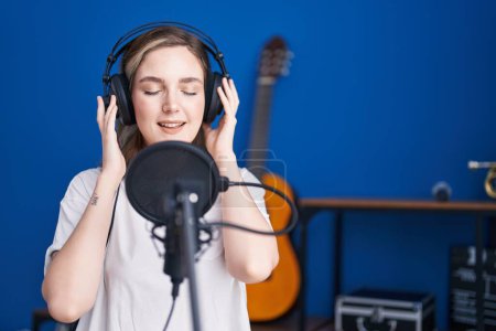 Téléchargez les photos : Young woman artist singing song at music studio - en image libre de droit