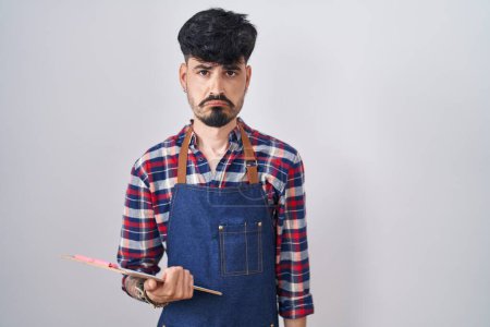 Téléchargez les photos : Young hispanic man with beard wearing waiter apron holding clipboard depressed and worry for distress, crying angry and afraid. sad expression. - en image libre de droit