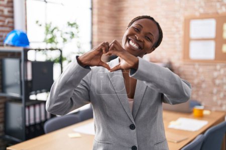 Foto de African american woman at the office smiling in love showing heart symbol and shape with hands. romantic concept. - Imagen libre de derechos