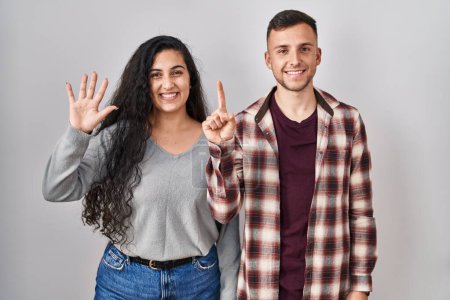Téléchargez les photos : Young hispanic couple standing over white background showing and pointing up with fingers number six while smiling confident and happy. - en image libre de droit