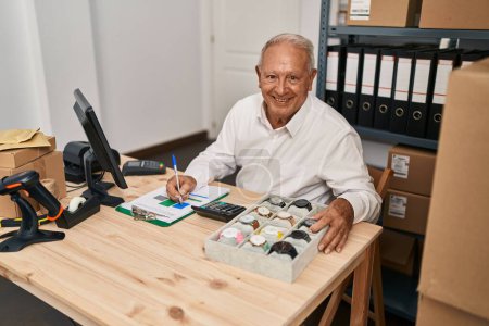 Foto de Senior man ecommerce business worker writing on clipboard at office - Imagen libre de derechos