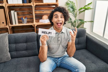 Photo for Hispanic man with curly hair asking for help celebrating victory with happy smile and winner expression with raised hands - Royalty Free Image
