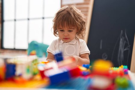Photo for Adorable hispanic toddler playing with construction blocks standing at kindergarten - Royalty Free Image