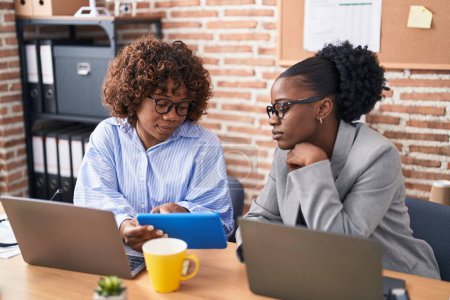Téléchargez les photos : African american women business workers using touchpad working at office - en image libre de droit