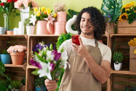 Photo for Young latin man florist make photo to flowers by smartphone at flower shop - Royalty Free Image