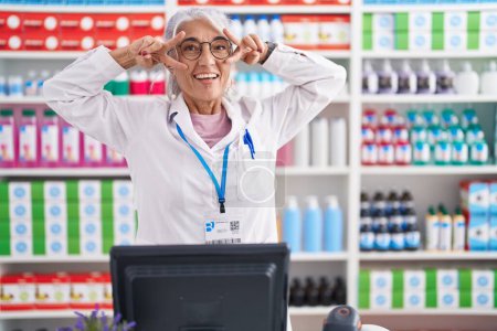Photo for Middle age woman with tattoos working at pharmacy drugstore doing peace symbol with fingers over face, smiling cheerful showing victory - Royalty Free Image