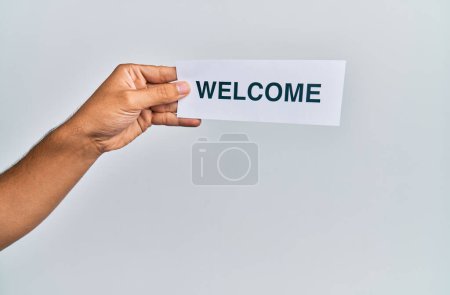 Téléchargez les photos : Hand of caucasian man holding paper with welcome word over isolated white background - en image libre de droit