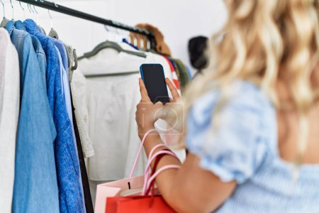 Téléchargez les photos : Young woman customer make photo to clothes at clothing store - en image libre de droit