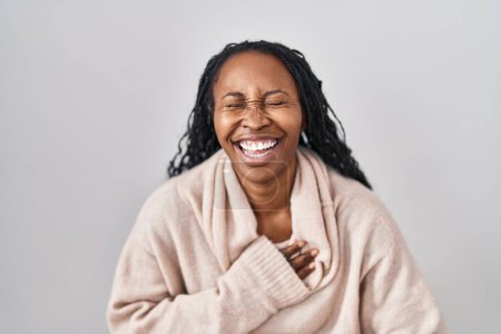 Foto de African woman standing over white background smiling and laughing hard out loud because funny crazy joke with hands on body. - Imagen libre de derechos
