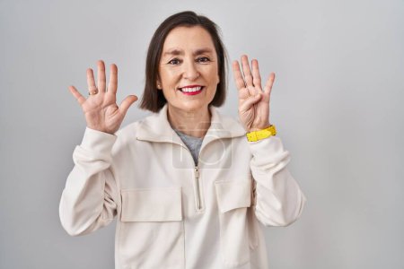 Téléchargez les photos : Moyen Age femme hispanique debout sur fond isolé montrant et pointant vers le haut avec les doigts numéro neuf tout en souriant confiant et heureux. - en image libre de droit