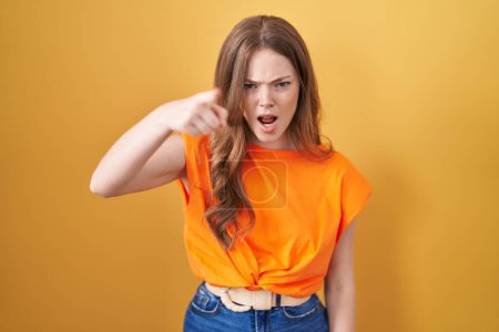 Photo for Caucasian woman standing over yellow background pointing displeased and frustrated to the camera, angry and furious with you - Royalty Free Image