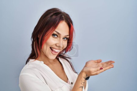 Photo for Young caucasian woman wearing casual white shirt over isolated background pointing aside with hands open palms showing copy space, presenting advertisement smiling excited happy - Royalty Free Image