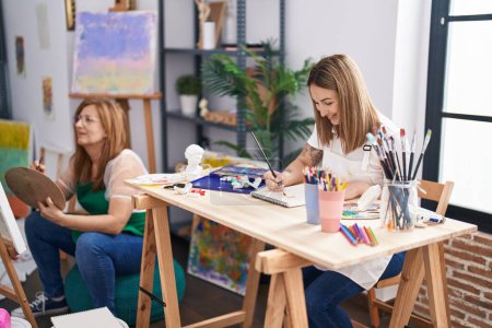 Photo for Mother and daughter artists smiling confident drawing at art studio - Royalty Free Image