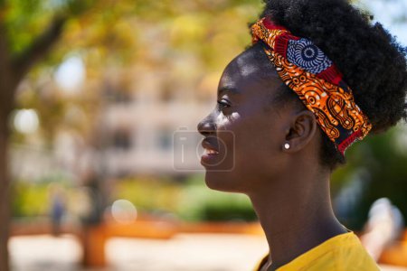 Foto de Young african american woman smiling confident looking to the side at park - Imagen libre de derechos
