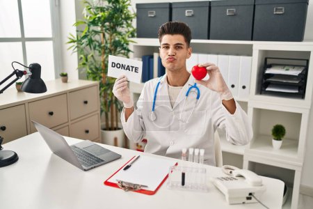 Photo for Young hispanic doctor man supporting organs donations looking at the camera blowing a kiss being lovely and sexy. love expression. - Royalty Free Image