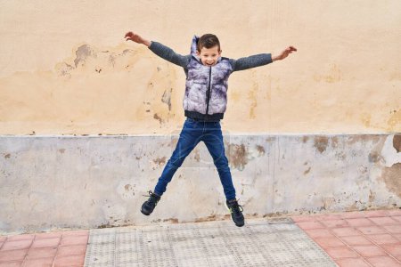 Téléchargez les photos : Blond child smiling confident jumping at street - en image libre de droit