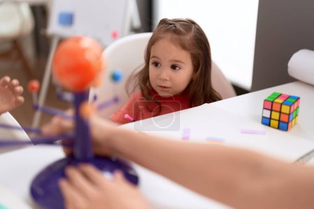 Photo for Adorable hispanic girl playing with toys sitting on table at kindergarten - Royalty Free Image