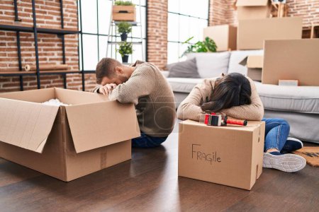 Photo for Man and woman couple packing fragile cardboard box at new home - Royalty Free Image