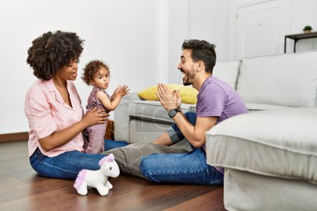 Photo for Couple and daughter smiling confident playing with toys sitting on the floor at home - Royalty Free Image
