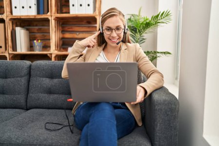 Téléchargez les photos : Young blonde woman working on online appointment smiling happy pointing with hand and finger - en image libre de droit