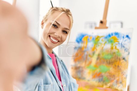 Foto de Young caucasian woman artist smiling confident make selfie by camera at art studio - Imagen libre de derechos