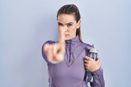 Photo for Beautiful woman wearing sportswear holding water bottle pointing with finger up and angry expression, showing no gesture - Royalty Free Image