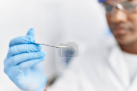 Photo for Young south east man wearing scientist uniform looking sample at laboratory - Royalty Free Image